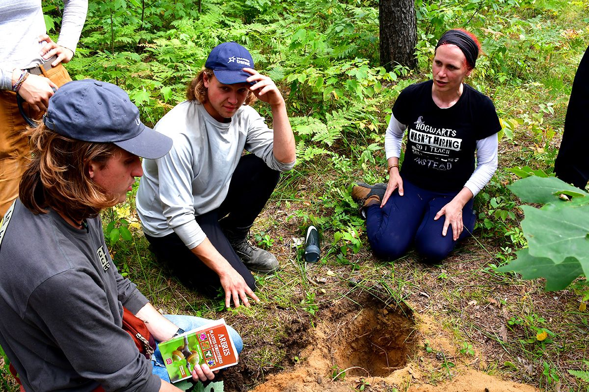 Professeure qui enseigne à des étudiantes dans la forêt