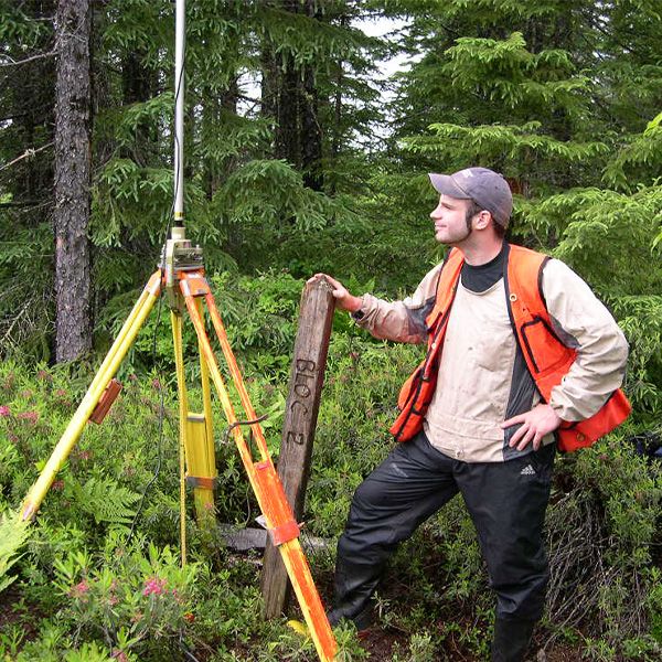 Étudiant en forêt qui prend des mesures avec un laser