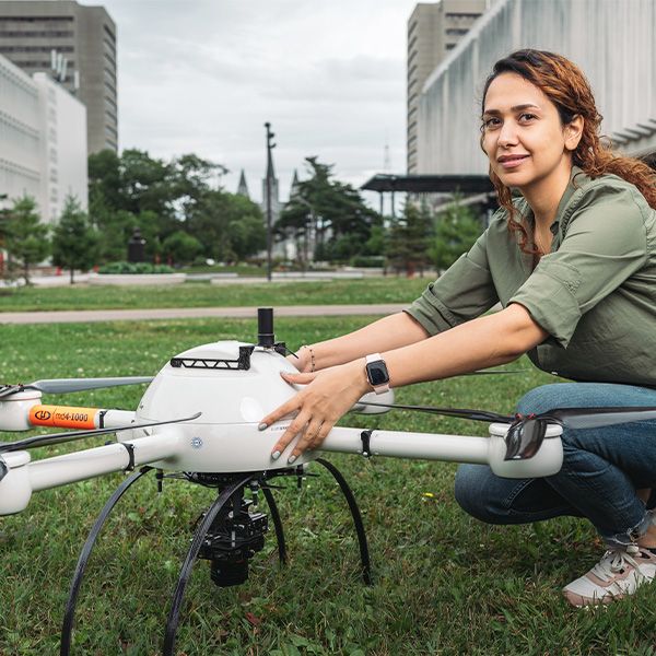 Étudiante dehors qui tient un drone